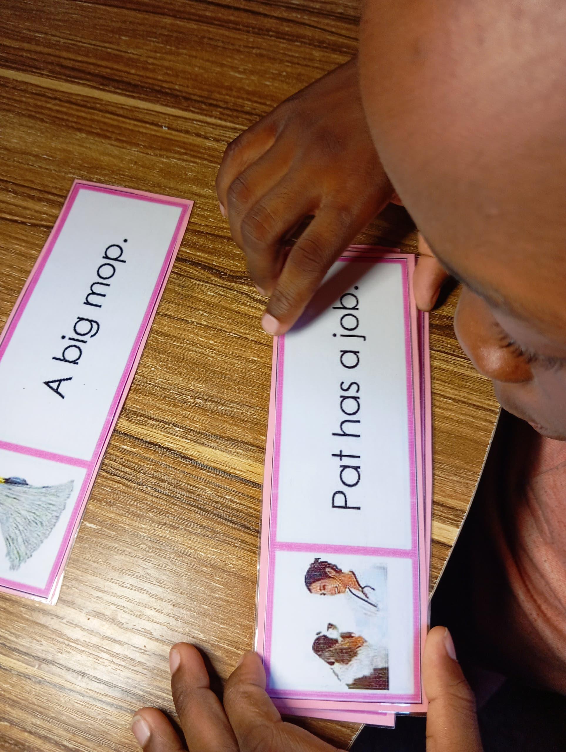 A child reading colourful phonics flashcards
